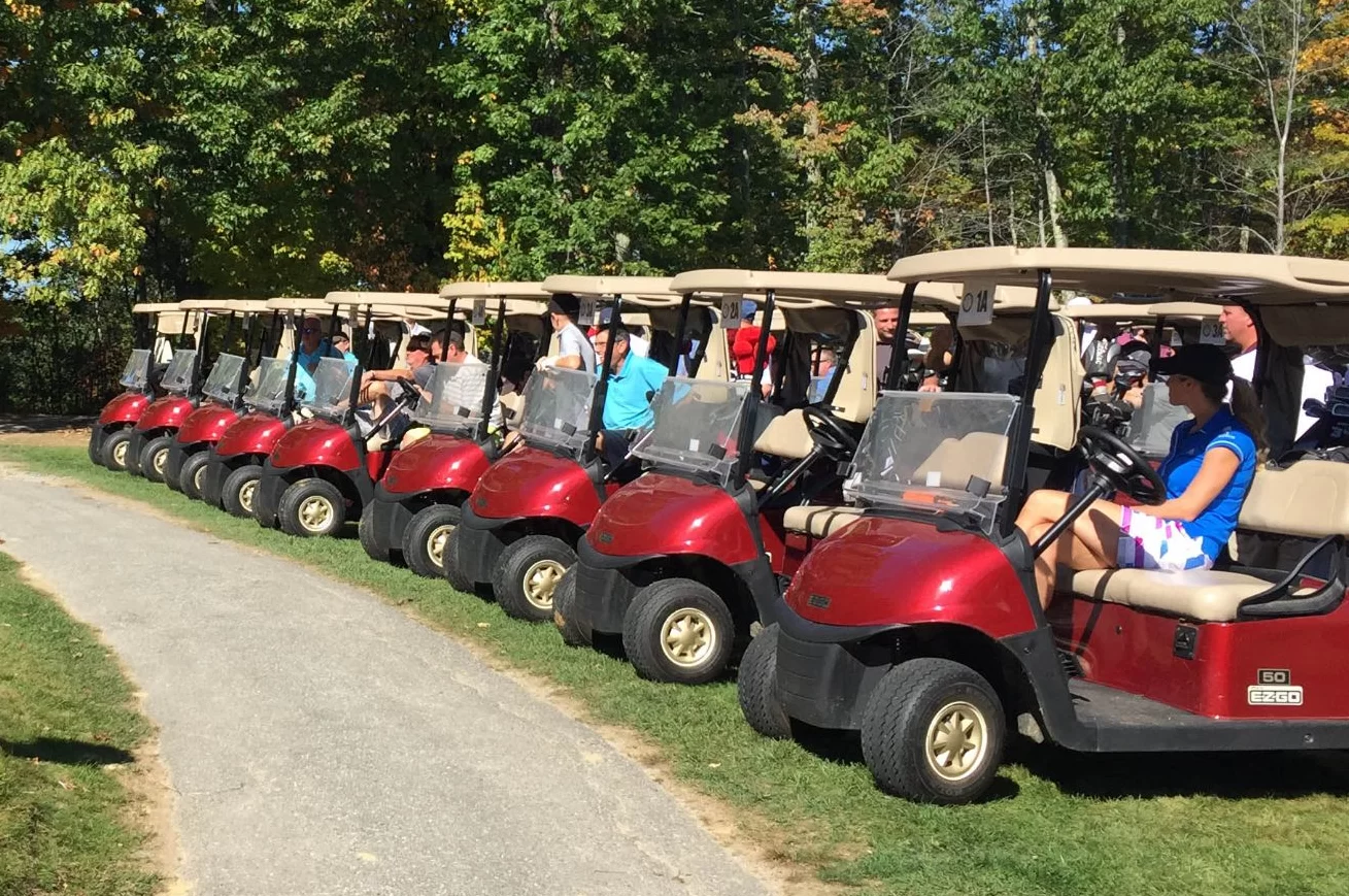 Photo from a past Basketball Golf Outing that shows lined up golf carts with participants inside of each.