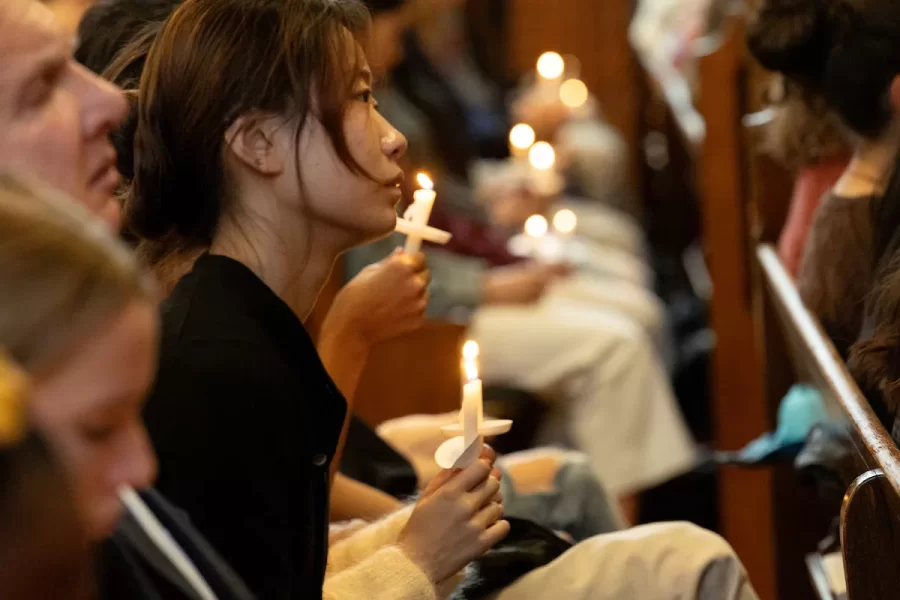 “The brightness that shines through the dark of a tragedy such as we have suffered here in Lewiston, our home, is what it always is in times like these: the immense capacity of our shared humanity,” said Bates President Garry W. Jenkins in his remarks during today’s Vigil for Grief and Remembrance, held at 4:30 p.m. in Gomes Chapel on the one-week anniversary of the shootings in Lewiston. Led by the Rev. Brittany Longsdorf, the college’s multifaith chaplain, the vigil gave the campus community an opportunity to come together for silence, candle lighting, poetry, and interfaith prayers, and, ultimately, to share communal grief with their Lewiston community. “We arrive at this moment as one community,” said Jenkins. “We must continue to support each other, just as we did in the hours and days after the tragedy. In doing so, we will move forward, move through this, together.” In her remarks, Longsdorf spoke of the power of sharing grief as a community. “Some may think that grieving is weak, or a form of surrender. But I believe that grief is a form of rest and a method of love. When we grieve together like this, in community, we powerfully hold each other and are held. When we grieve, we continue loving amidst loss. When we remember, we root to purpose and commit to change. When we remember, we connect the threads of the dead to how we still want to live our one precious life.” In addition to brief remarks by President Jenkins and Lewiston Mayor Carl Sheline, the vigil included the reading of the names of the 18 people killed in the shootings, readings by Bates students and local faith leaders, and musical performances. “Lewiston is your city, just as much as it is mine,” Sheline told the packed chapel audience. “Together we are sharing in this tragedy. Flash forward to now: Together, we will be joining the recovery and healing, too. We will stand shoulder to shoulder together, and therefore we will rise together.” The service concluded with remarks by the Rev. Raymond Clothier, associate multifaith chaplain.