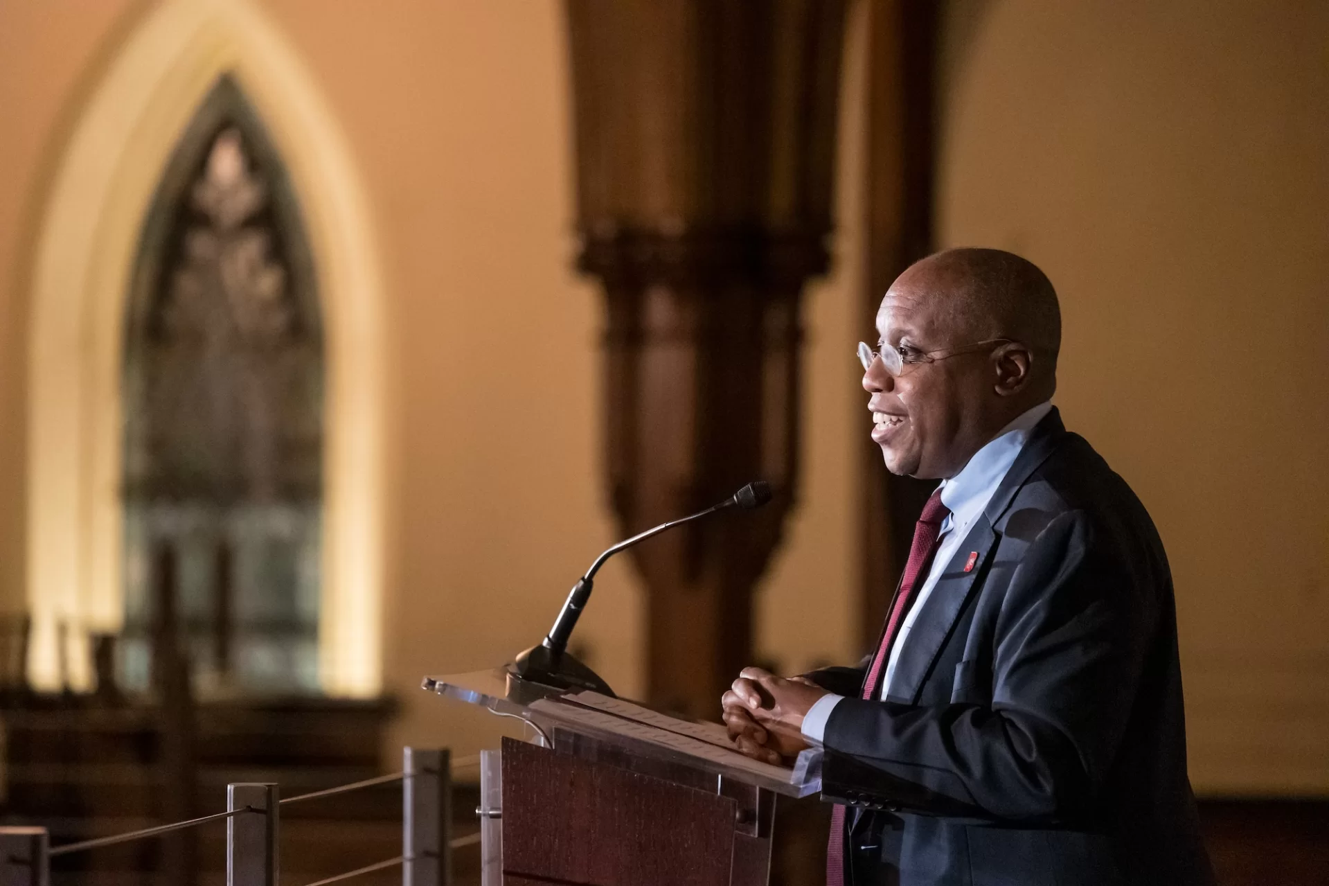 Garry Jenkins speaking into microphone at the podium in the chapel