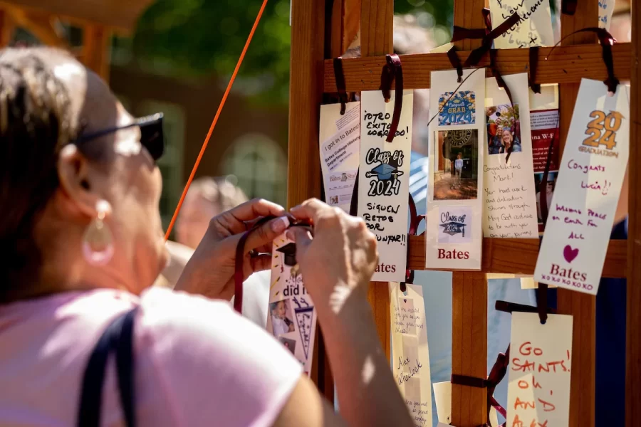 A family members ties a blessing tag on an arch