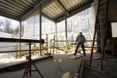 A carpenter at work in the fireplace lounge at the new student housing. (Phyllis Graber Jensen/Bates College)