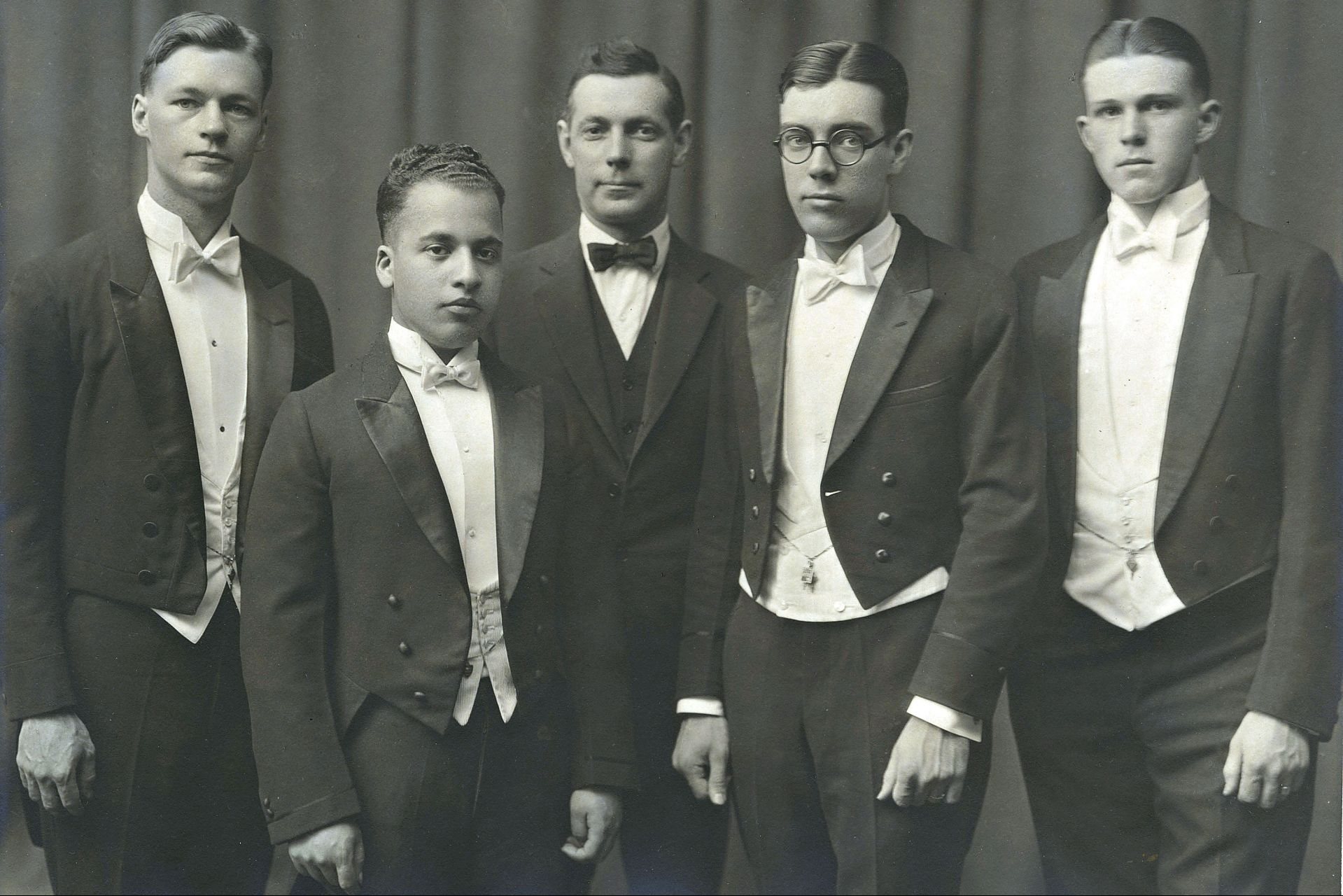 four early 20th century debaters and their coach in formalwear