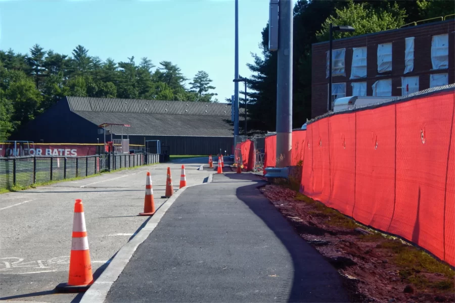 The first of two coats of asphalt on this new sidewalk alongside 96 Campus Avenue was placed on July 1. The topcoat isn't due till late in the building’s renovation. This walk connects to a major east-west walkway  at the left end of Alumni Gym, at rear. (Doug Hubley/Bates College)