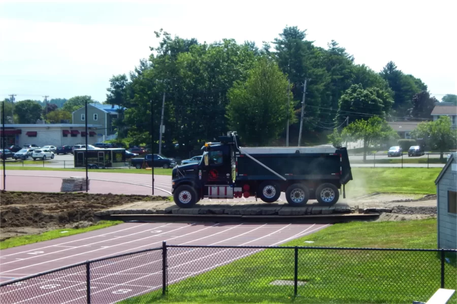 Shown in mid-July, this wood-and-steel ramp enabled heavy equipment to cross into the Russell Street Field work zone without damaging the track surface, which is just a couple years old. (Doug Hubley/Bates College)