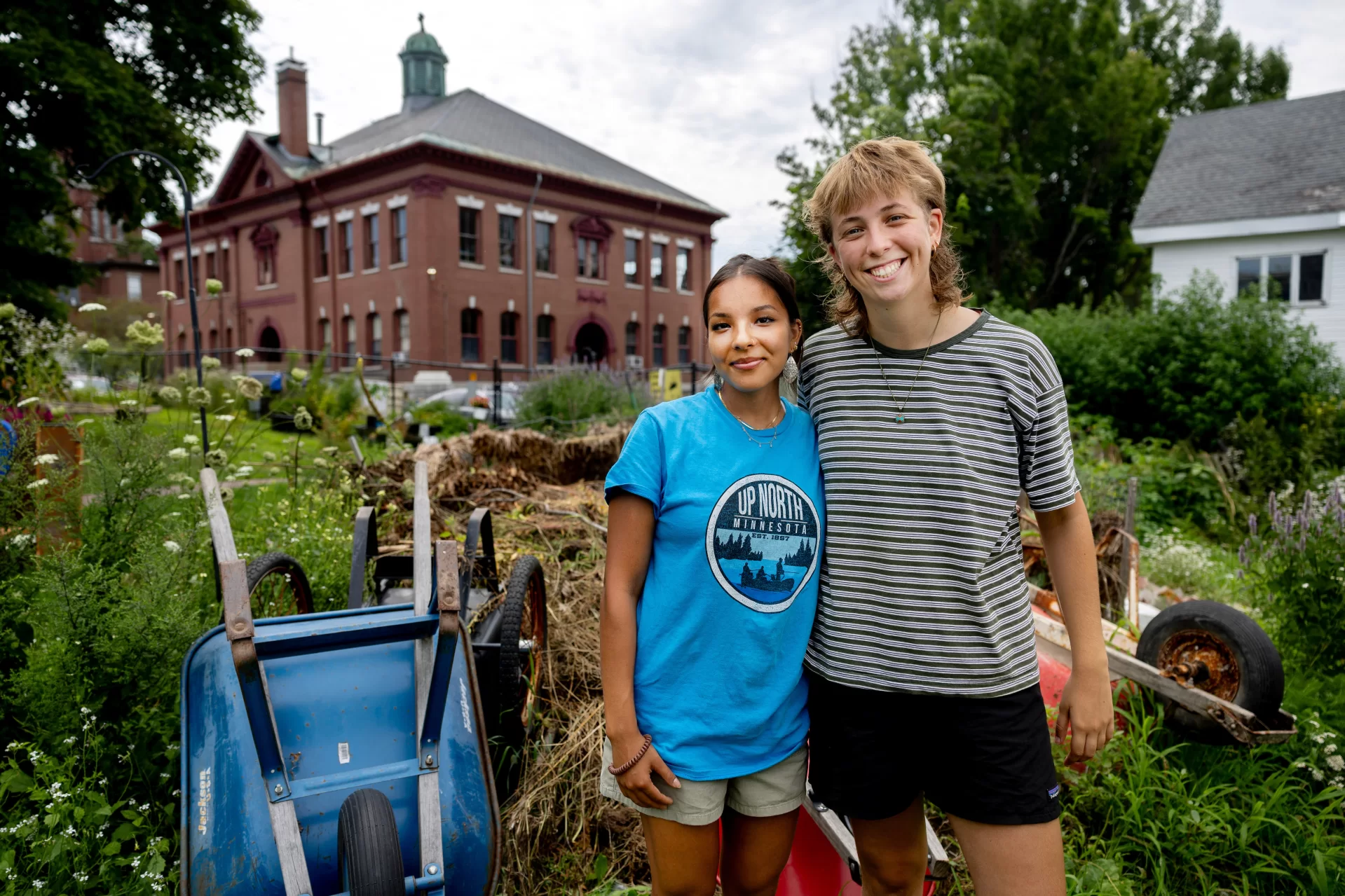 two college students standing in a vegetable garden