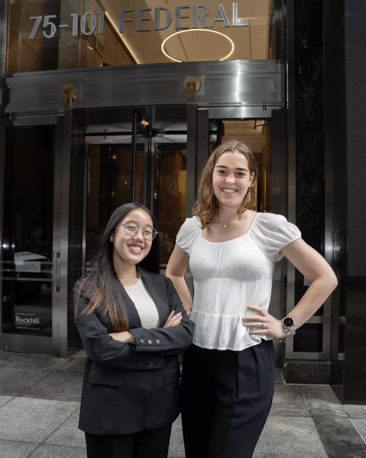 two students posing in front of an office building