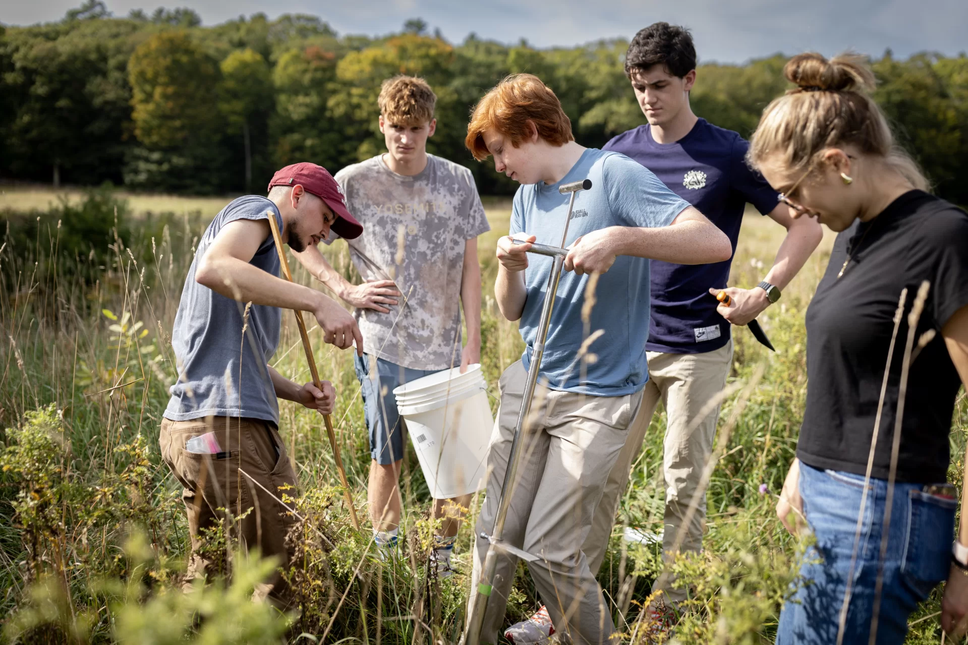 In this photo (left to right) Post-baccalaureate scholar Sebastián Leon Fallas, Junior Trent Hieber, Junior John Harun-Delong, Sophomore Ben Leach, and Senior Bryn Murray (Teaching assistant). Sebastián is instructing John how to collect a soil core sample from Fable Farmstead in Freeport - a farm that was impacted by PFAS contamination. This will allow us to understand how these forever chemicals affect the biology of the soil.