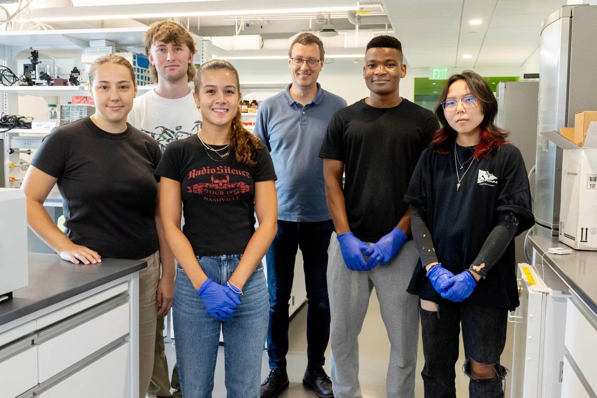 group of students and professor posing in a lab