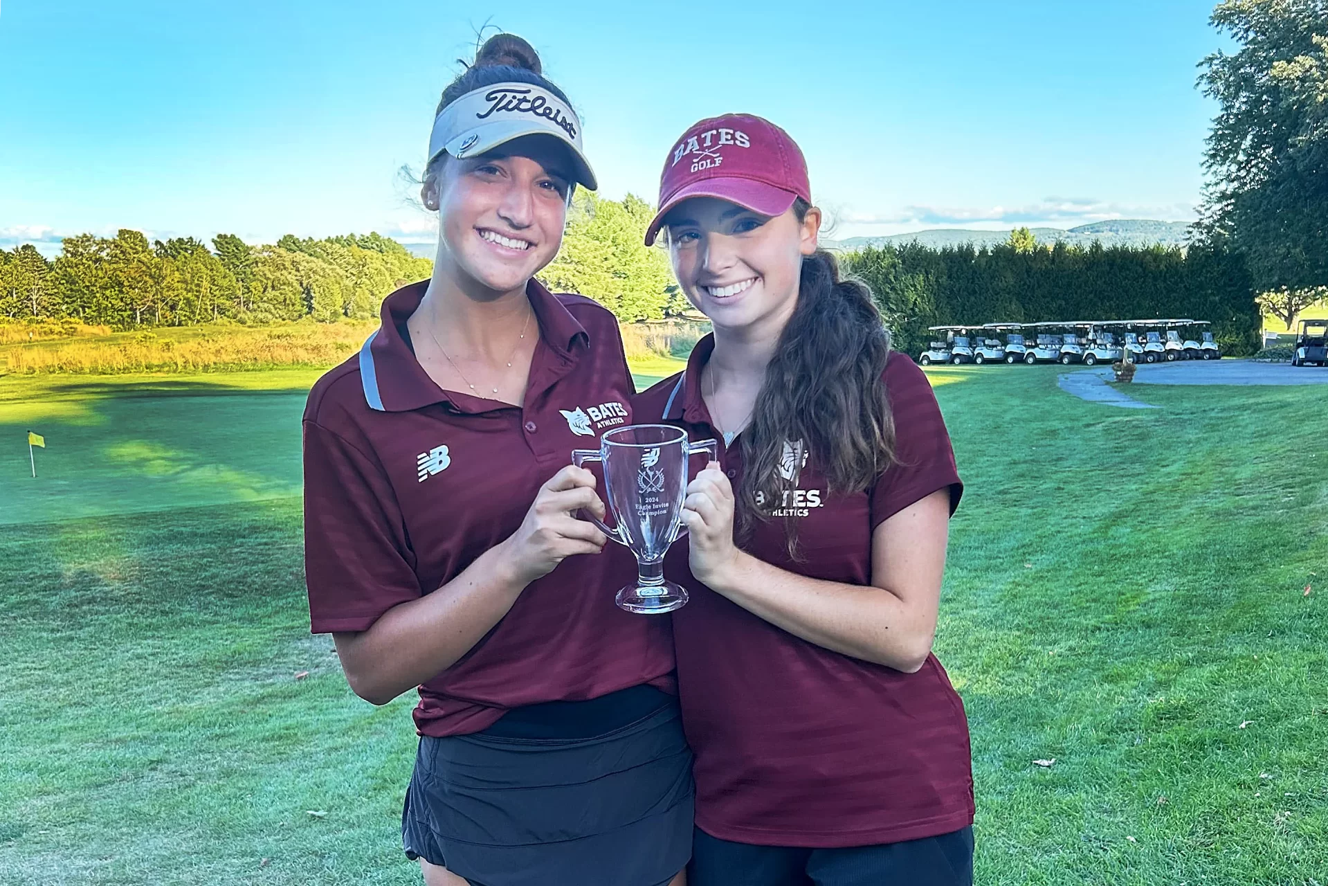 two golfers holding trophy