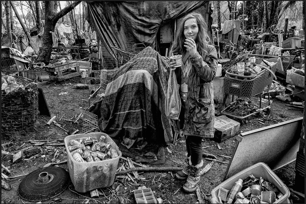 unhoused person in an encampment outside.