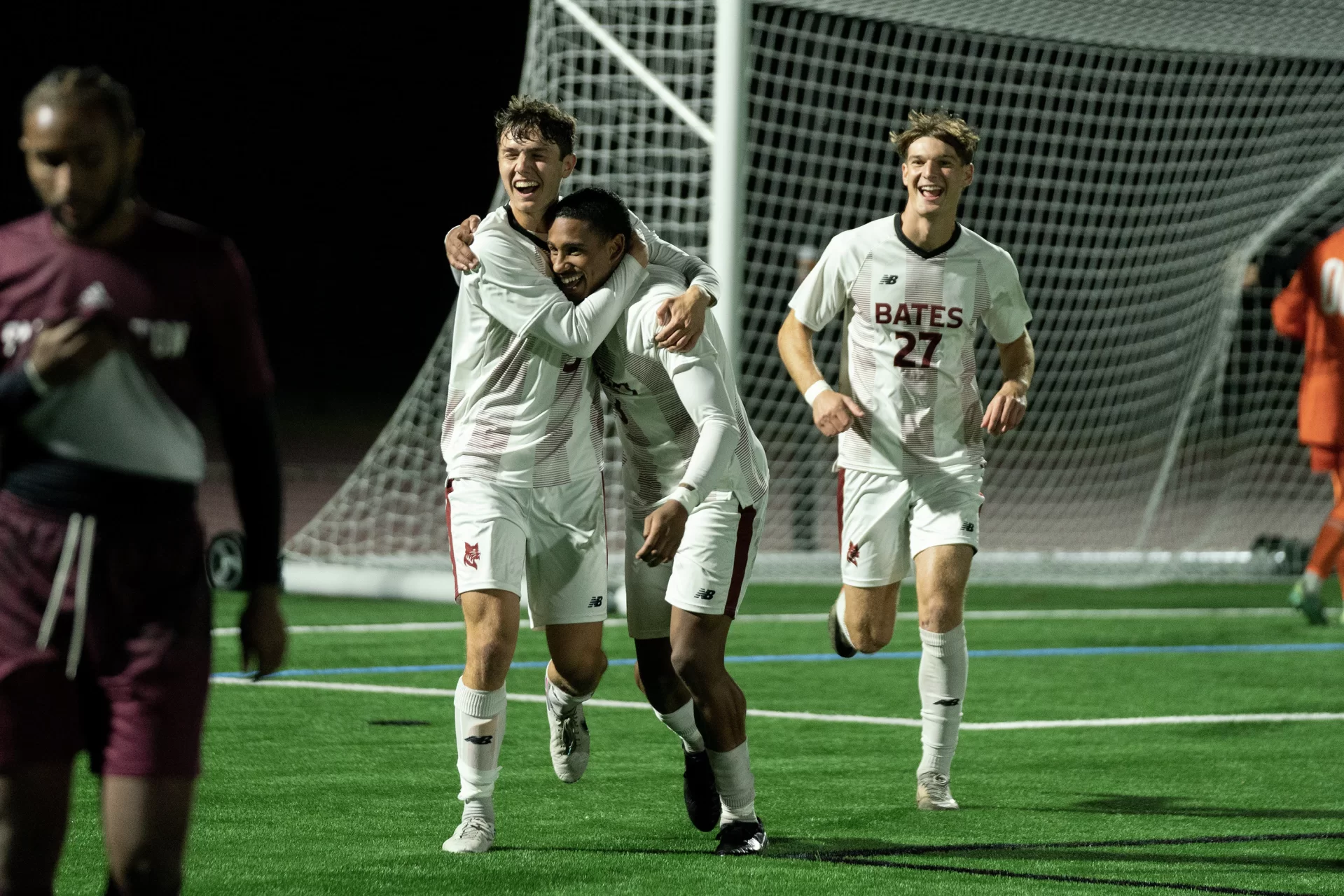 three soccer players celebrating a goal