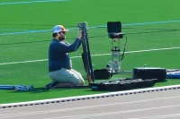 Corbin Cleary, a field technician for Firefly Sports Testing, sets up equipment on the new turf at Russell Street Field. Firefly collects turf performance data for manufacturer FieldTurf. (Doug Hubley/Bates College)