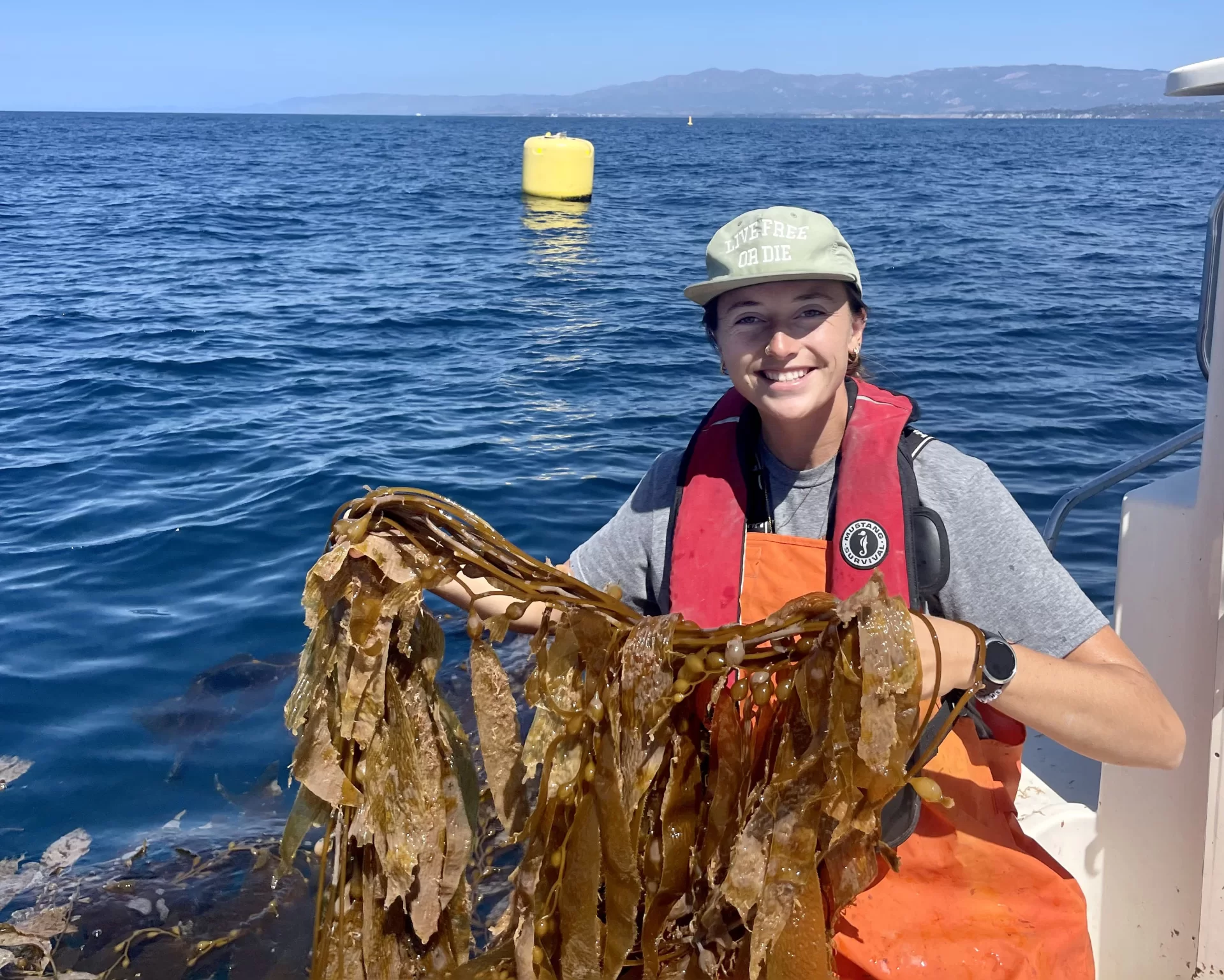 student holding kelp in a boat