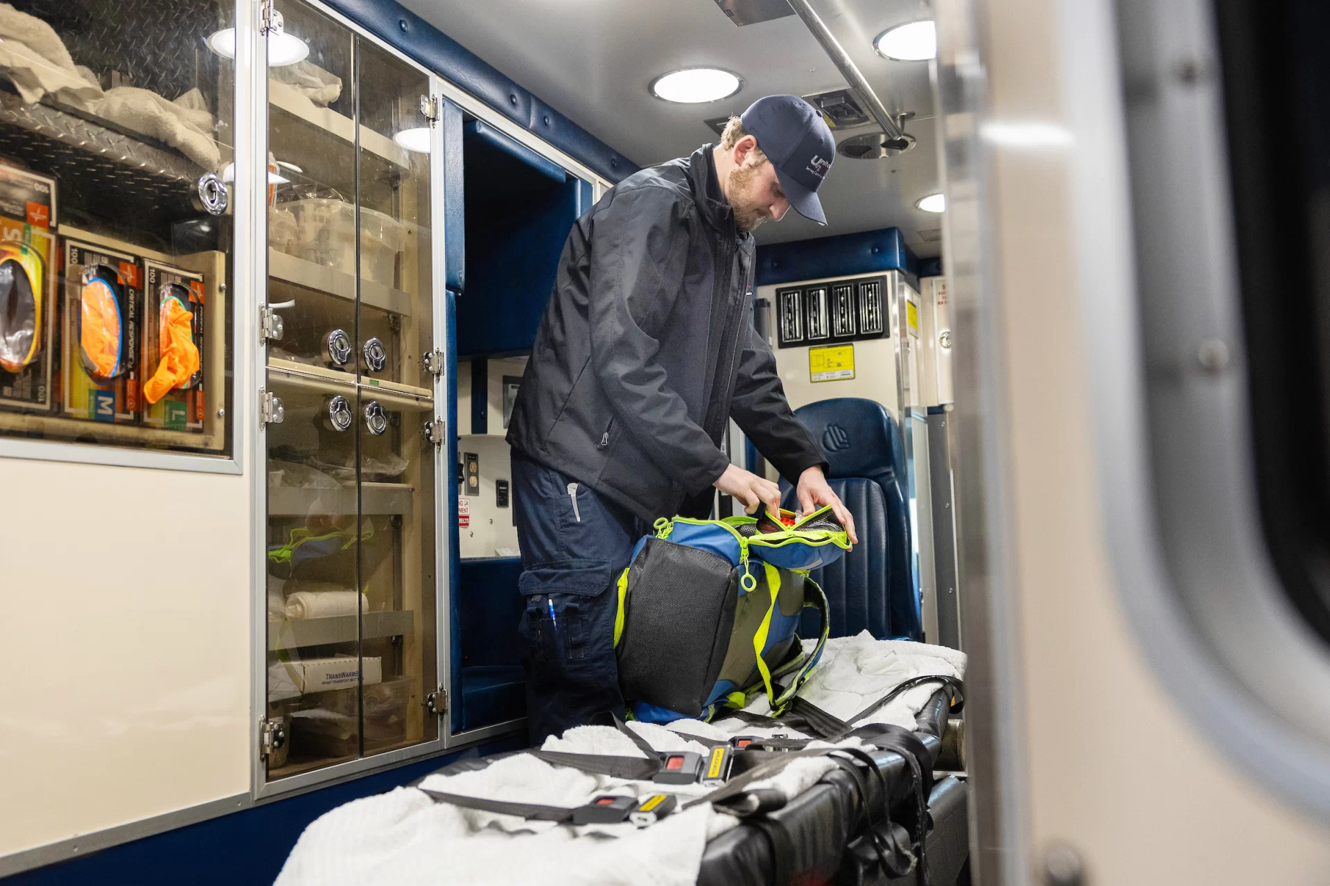 Bates EMS co-chief Ned Friedman ’24 of Park City, Utah, and Noah Bachner ’25 of Weston, Conn., work their overlapping shifts on Sunday, March 31, at Lewiston’s United Ambulance on Russell Street. Shadowing Ned (with the fuller beard and mustache) for the day is first-year Maggie Gill of Tenants Harbor, Maine. Pictured also is EMT Dakota Hern in the United kitchen.