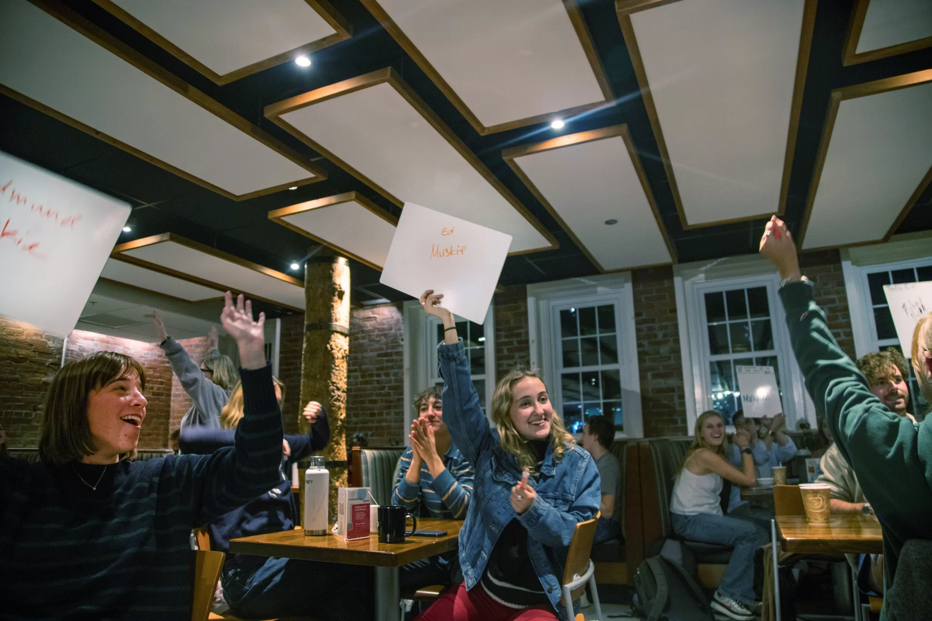 students holding signs that are trivia answers