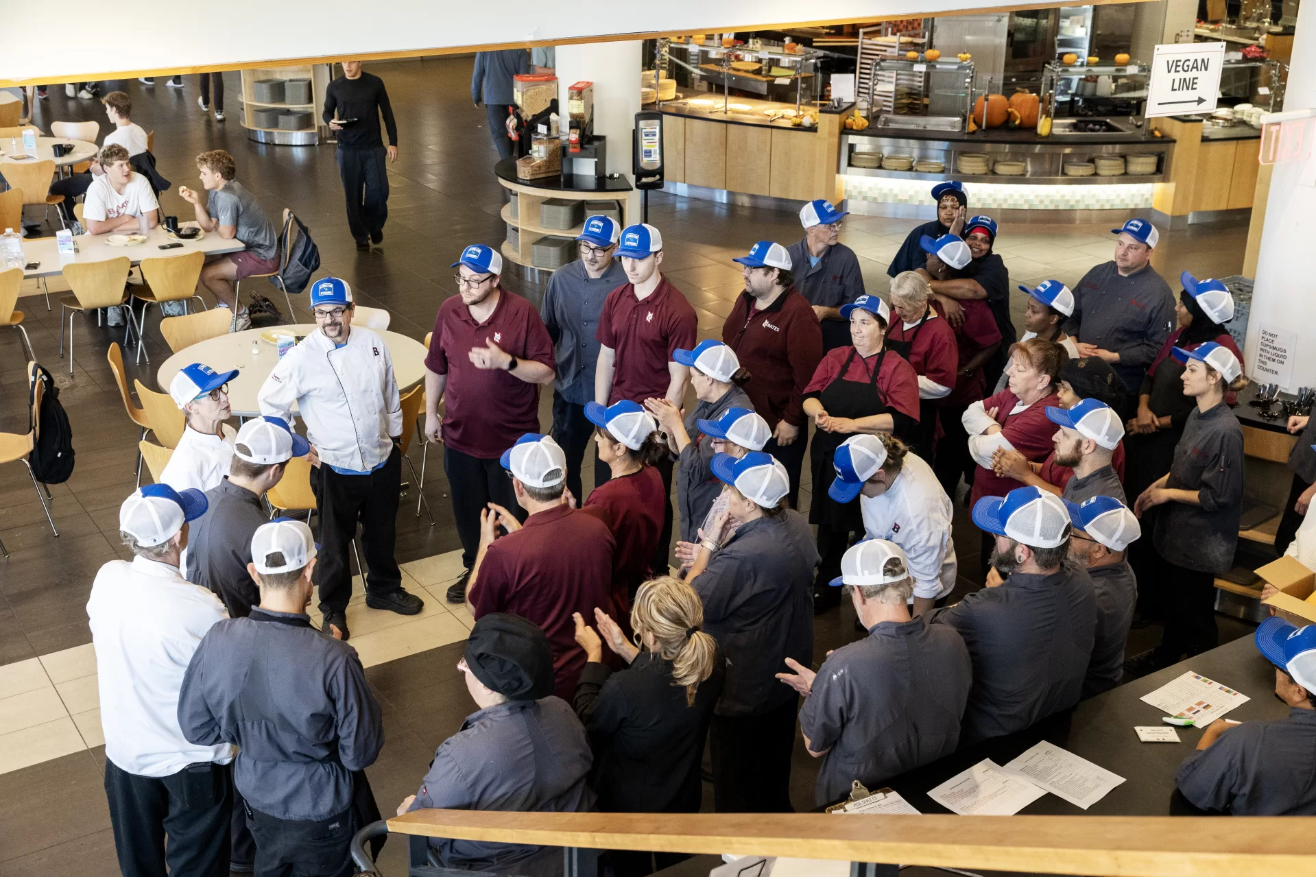 DCCE staff seen working in Commons on October 25, 2024. DCCE staff can be seen wearing blue Lewiston Strong baseball hats in remembrance of last year’s massacre. 

(Theophil Syslo | Bates College)