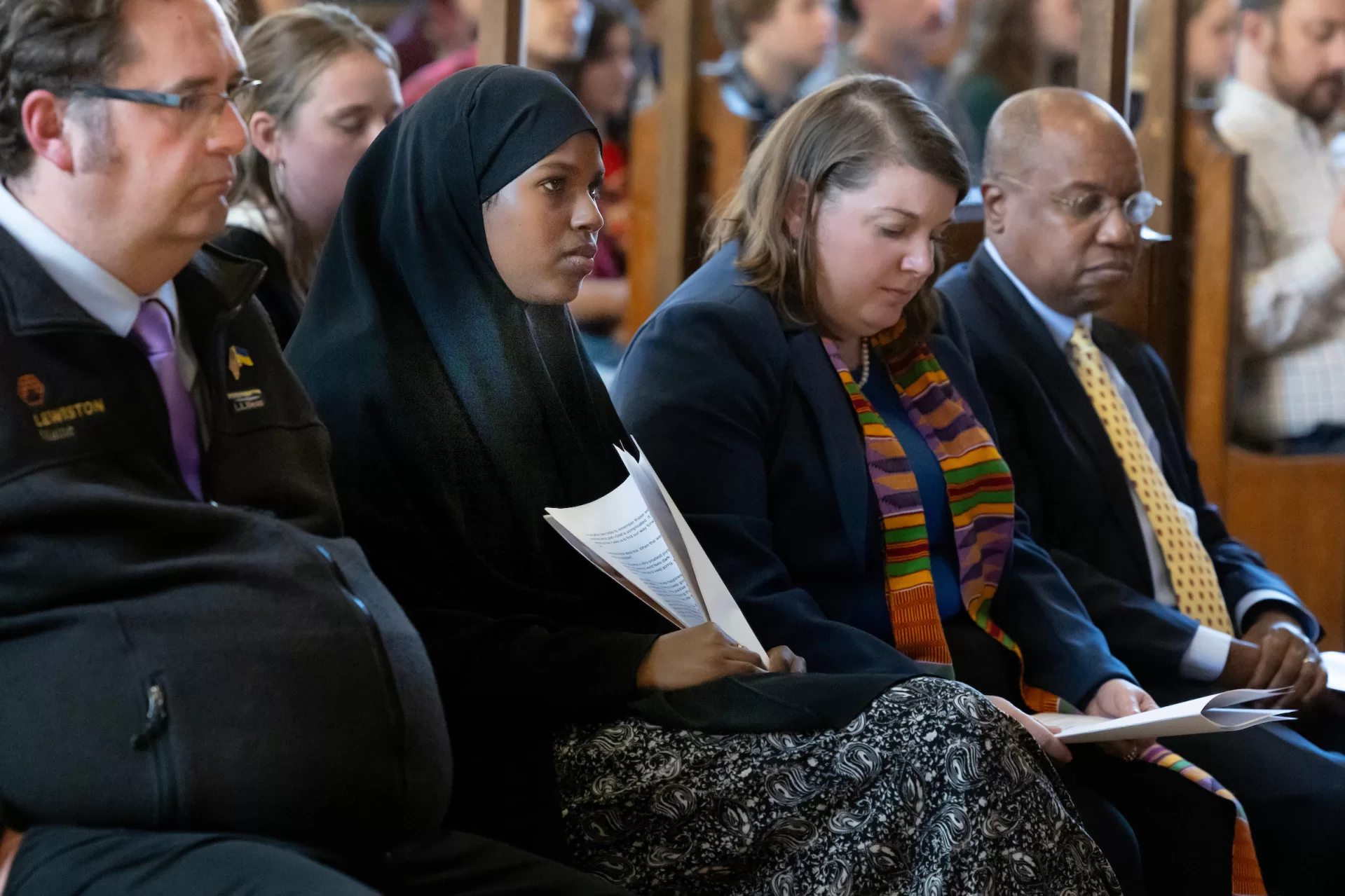 From left, Lewiston mayor Carl Sheline, Anzal Isaak '26 of Lewiston, the Rev. Brittany Longsdorf, and President Garry W. Jenkins. Isaak spoke during the service, saying that"on the hardest days, hope doesn't always look like happiness or excitement. Sometimes hope is just a quiet resilience — the ability to keep going, to find something to hold on to, even in our saddest moments." (Phyllis Graber Jensen/Bates College)