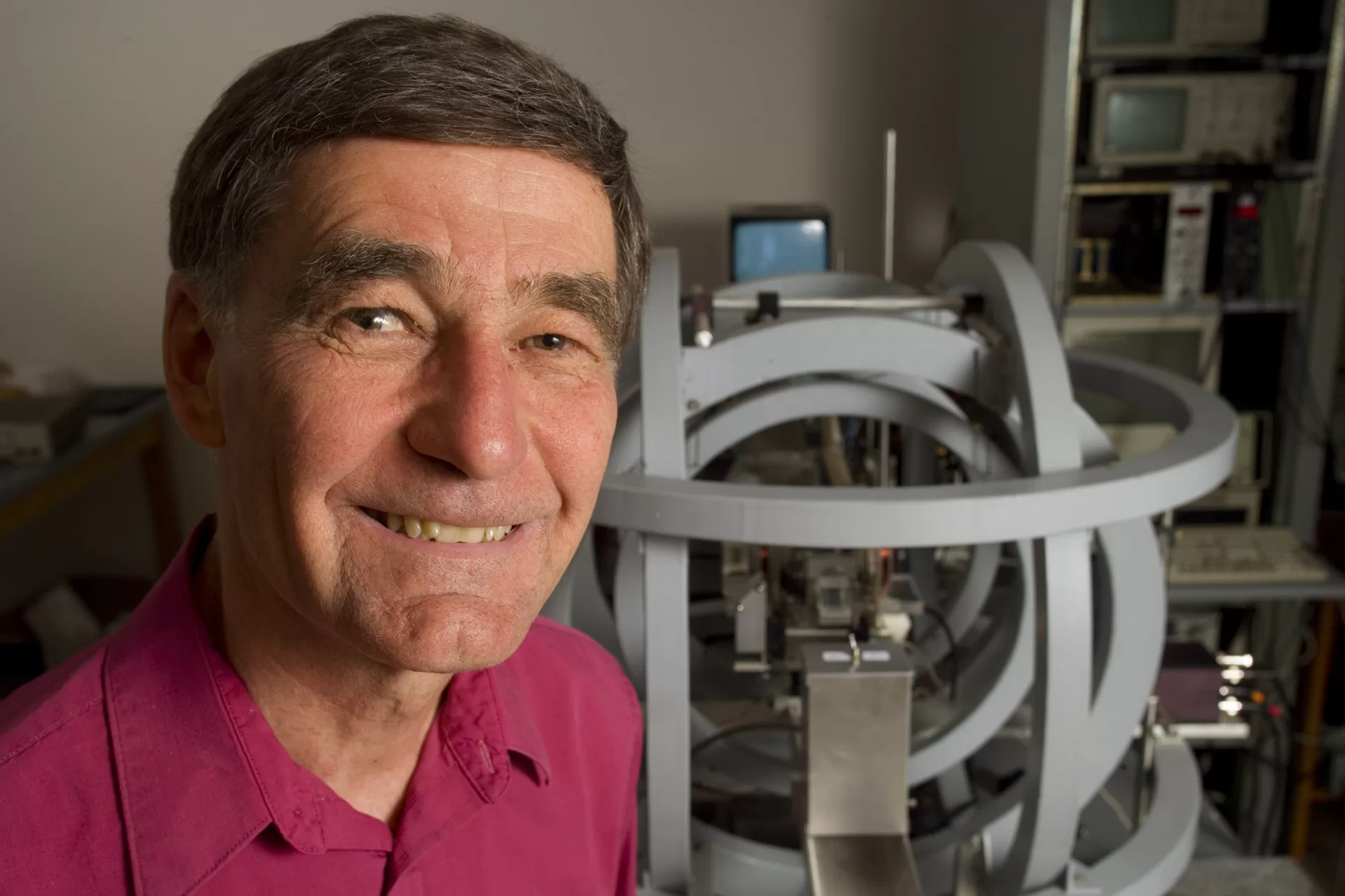 Charles A. Dana Professor of Physics George Ruff poses with an optical pumping apparatus set up as a spin echo experiment, in Carnegie Science. Ruff built the exterior coils as a graduate student. The rest of the machine was built at Bates by his students who, over the years, used the equipment to work on their theses.