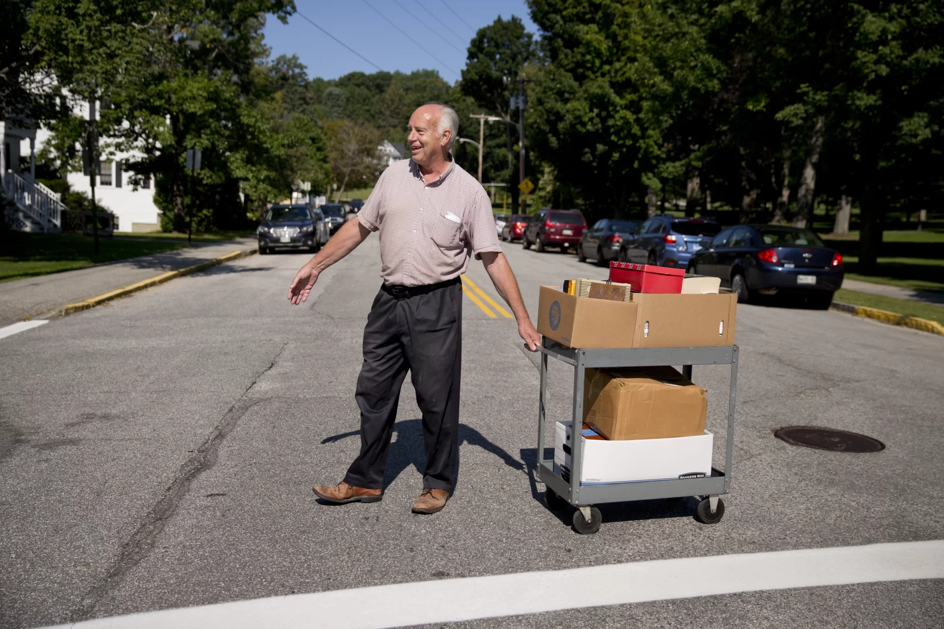 Geology Lecturer in Physics Gene Clough crosses Campus Avenue with some materials he is moving from one office to another.