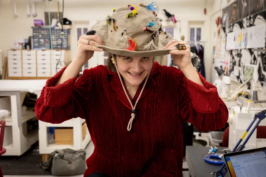 Carol Farrell, supervisor of the Bates Theater Department’s costume shop, and costume designer for the theater department’s upcoming production of Shakespeare’s “Much Ado About Nothing,” is leaning on for a neat costume change from 16th-century Italy, to Bar Harbor, Maine, in 1945.

Here she works on Feb. 2, 2023, with Adelle Welch ’25 (garnet sweater) of Livingston, Mont., a double major in and earth and climate science and dance and Jenna Perry ’25 (gray sweater), a psychology major from Las Vegas.

Welch designed a bucket hat with lures for the production.