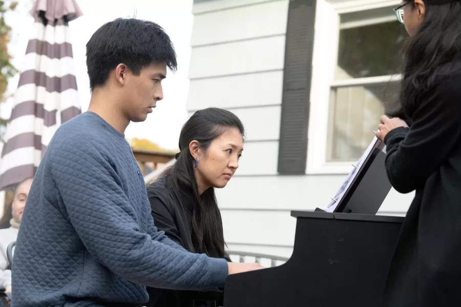 A visit to the Looking Ahead Clubhouse in Lewiston by the Gather Hear Tour by pianist Miki Sawada (seen at the piano). Looking Ahead is a program for adults with mental illness based on the Clubhouse Model of Rehabilitation. Jahan Baker-Wainwright ’25 (blue crewneck sweater), a biochemistry major from Cottage Grove, Wis., performed Beethoven’s Pathetique Sonata, op. 13, the third movement, on the piano. Assistant Professor of Music Zen Kuriyama (down coat) sang Franz Schubert’s “Der Doppelgänger” and “An die Musik,” accompanied by Miki Sawada on piano. Marrich Somridhivej ’26 (quilted pullover), a biology major from South Windsor, Conn., performed Amy Beach’s “Summer Dreams,” op. 47, no. 2 and 3, with Miki Sawada on the piano (four hand). Chiharu Naruse (glasses, black coat), Bates piano teacher, collaborative pianist, is seen at the picnic table and as a page-turner when the wind came up.