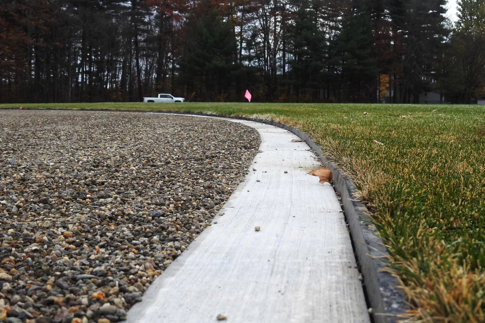 A concrete curb separates living grass on Bates’ baseball field from the area where artificial turf will be laid. the 