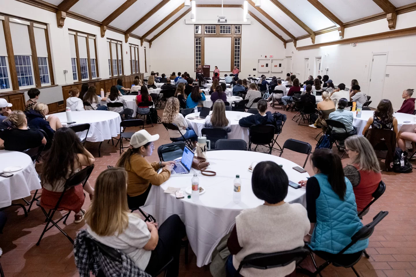 students around tables in big hall