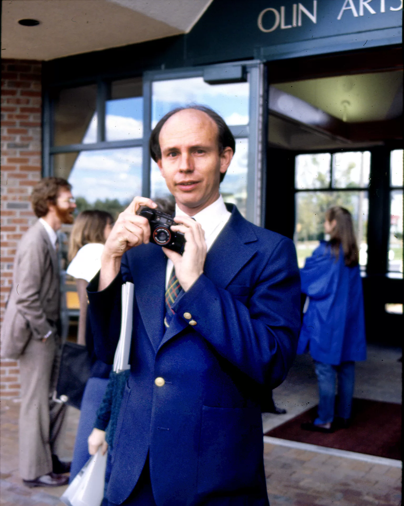 man holding camera wearing blue suit