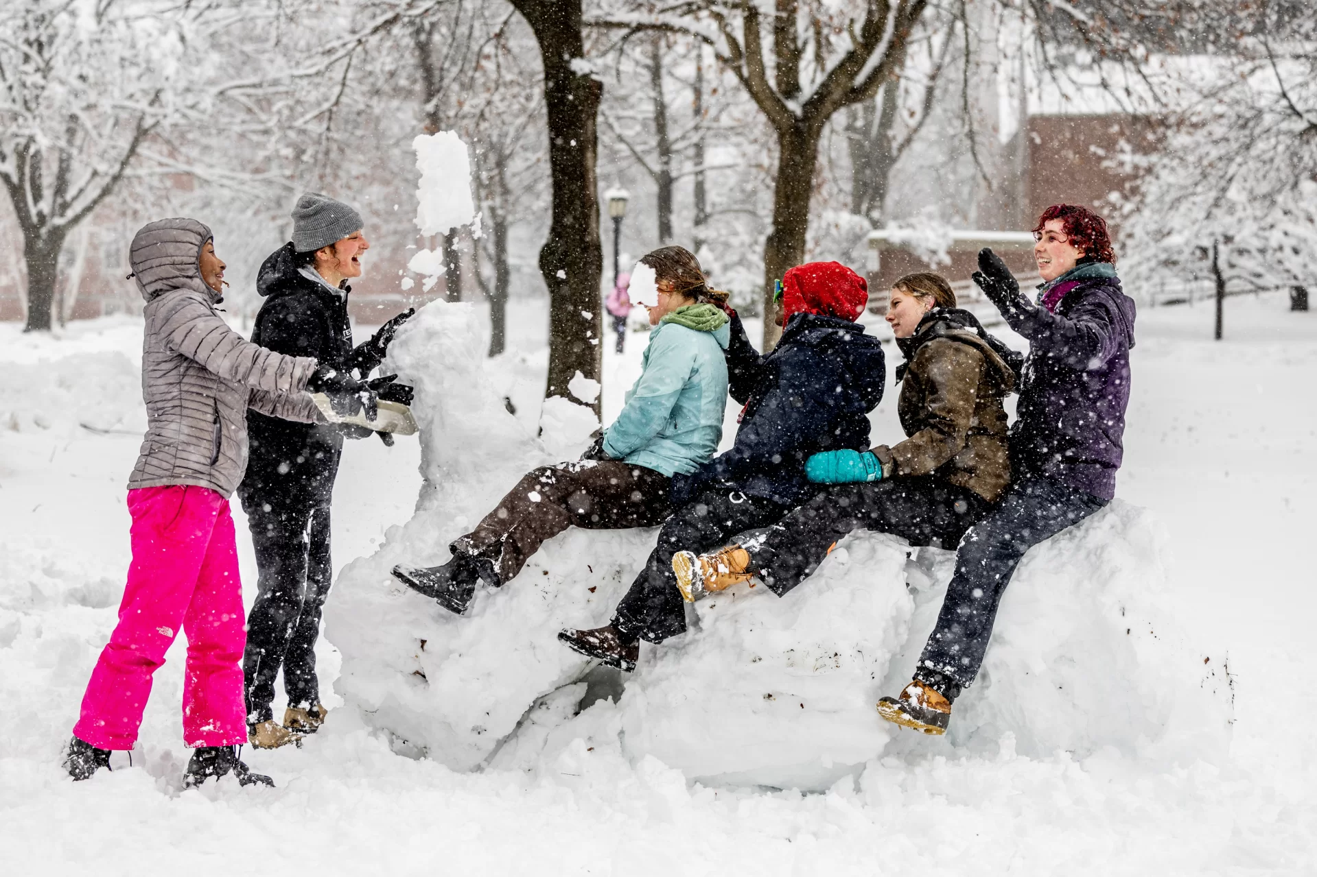 With heavy snow falling (nearly a foot by midday), Amelia Wallis ‘24 of Norwich, Vt., celebrated her 22nd birthday with Bates buddies, who threw her a snow party on the Historic Quad. “It’s an amazing day to celebrate with friends,” said Wallis. You can spy Wallis in her aqua blue jacket, seated at the head of a snow horse, which followed a snow fort they built from a big pile of snow left by Facility Services plows. A magnificent effort to match the day’s spring storm.