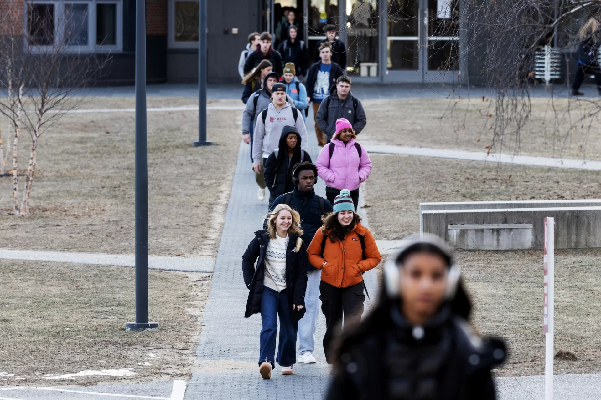 Katie Ney ‘25 of Baltimore, Md., center left, and Emma Sablan ‘25 of Norwich, Vt., center right, head towards Pettengill Hall after visiting Commons on the first day of winter semester classes on January 8, 2025. (Theophil Syslo | Bates College)