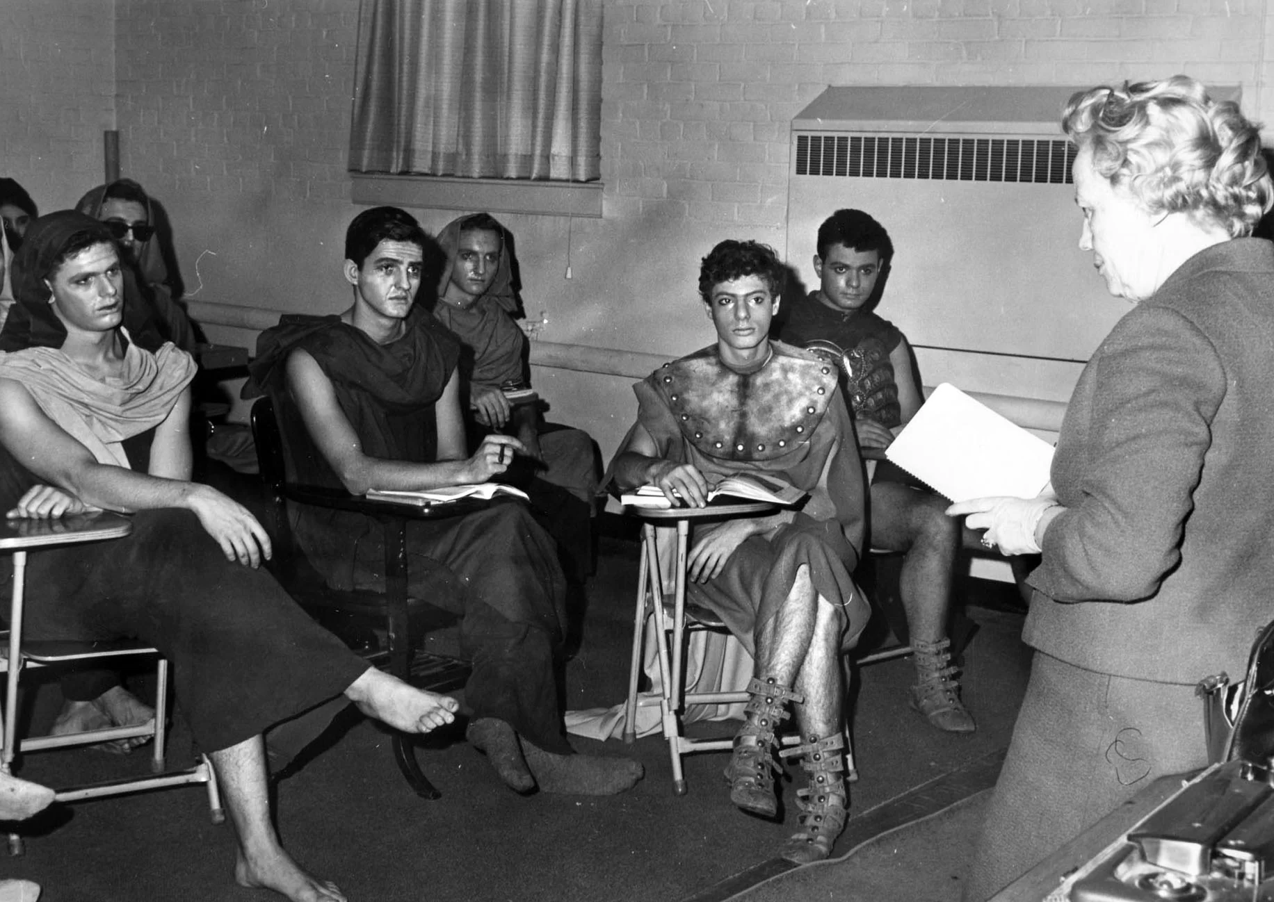  In February 1965, Lavinia Schaeffer gives notes to her costumed actors in the Robinson Players’ production of <em>Antigone. </em>(Muskie Archives and Special Collections Library)