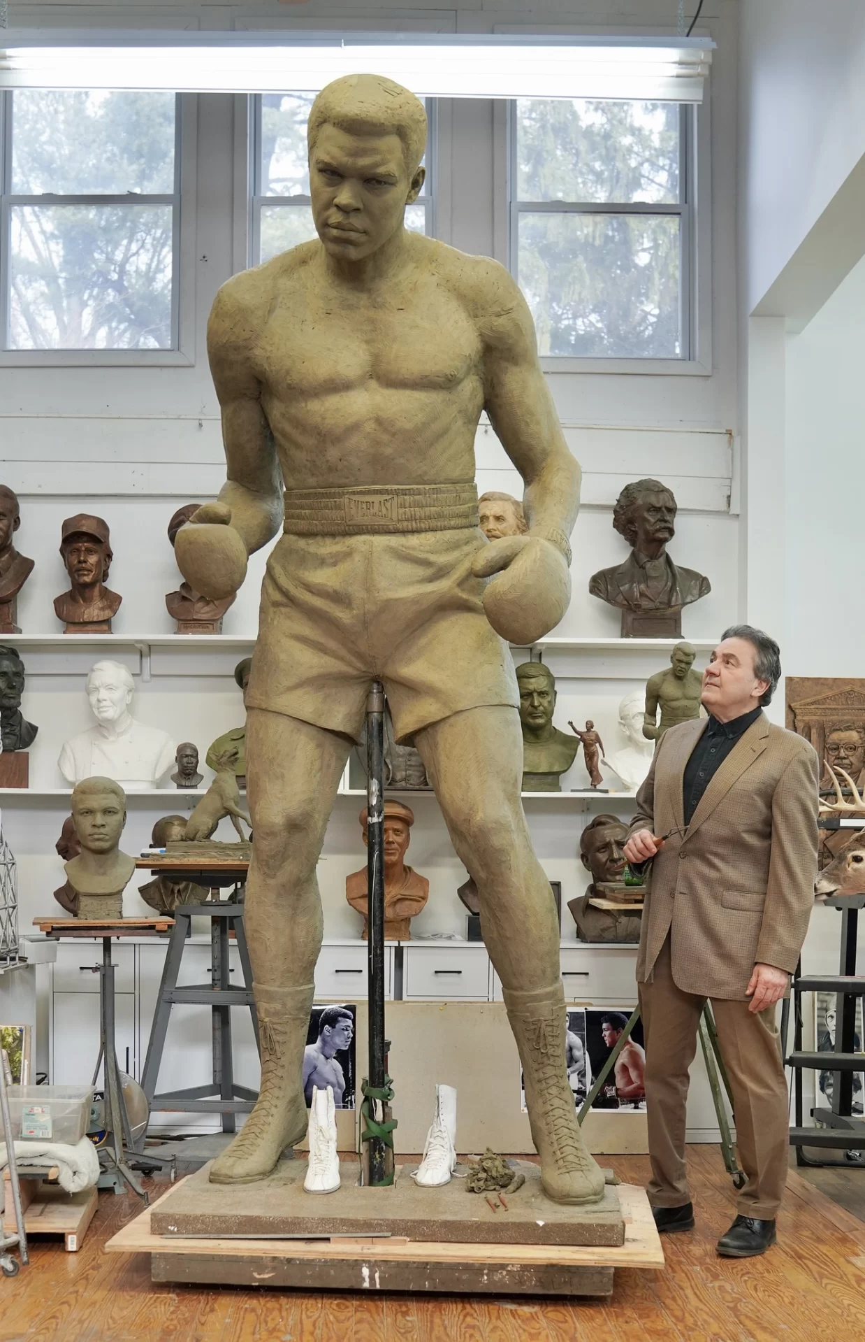 Sculptor Zenos Frudakis poses in late 2024 next to the clay version of his Muhammad Ali statue, a predecessor to the bronze statue to come. (Courtesy of Frudakis Studio Inc.)