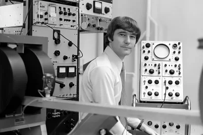 scientists sitting before physics equipment